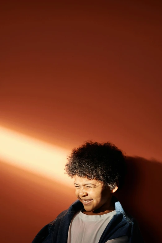 a man standing in front of a wall holding a tennis racquet, an album cover, pexels contest winner, curly afro, back light, thinker, ignant