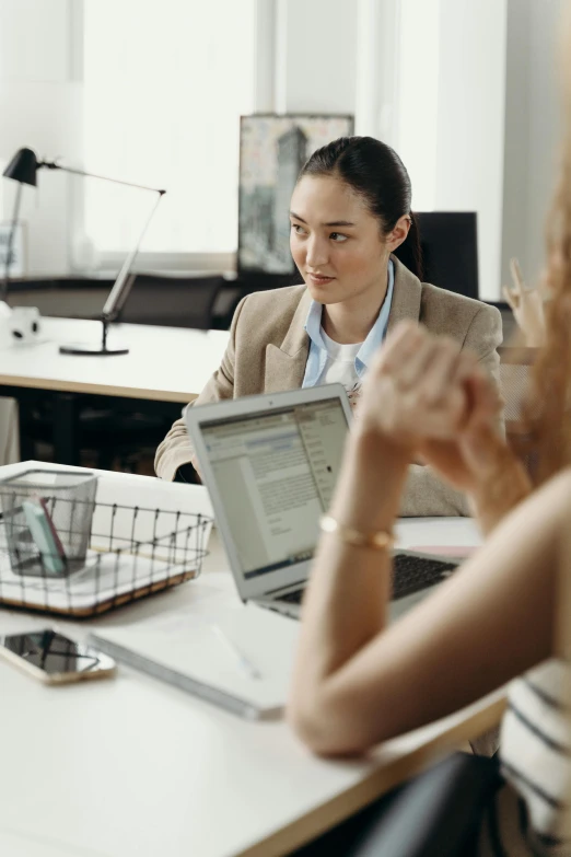 a group of people sitting around a table with laptops, trending on pexels, female in office dress, medium shot of two characters, asian female, thumbnail