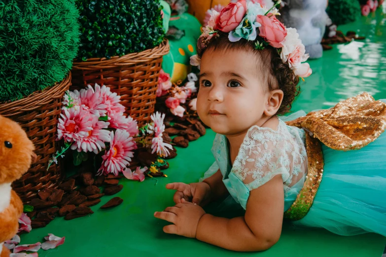 a little girl laying on the ground next to a teddy bear, pexels contest winner, hurufiyya, big crown adorned with emerald, avatar image, covered with flowers, full body close-up shot