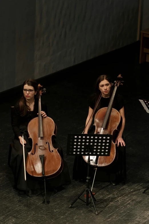 a group of people playing musical instruments on a stage, by Elizabeth Durack, antipodeans, cello, [ cinematic, twins, university