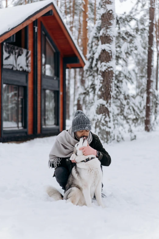 a person sitting in the snow with a dog, chalet, petri rahkola, kissing, profile image