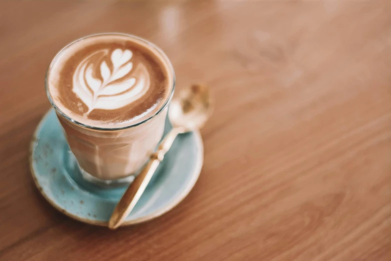 a cup of coffee sitting on top of a saucer, trending on unsplash, milkshake, wooden coffee table, profile image, fan favorite