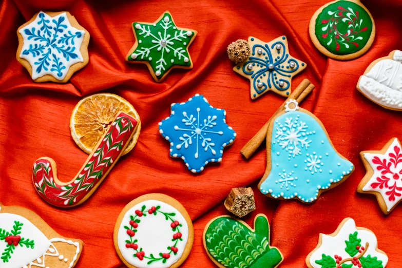 a bunch of decorated cookies on a red cloth, by Julia Pishtar, decorative ornaments, thumbnail, fan favorite, winter season