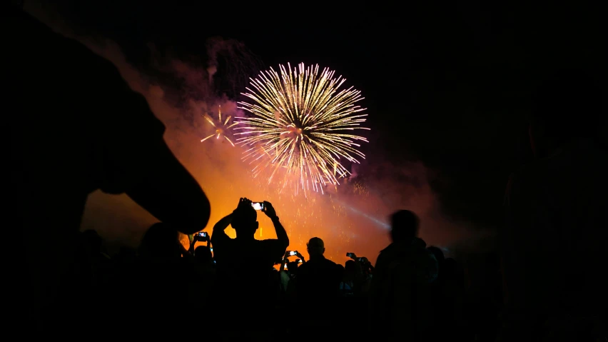 a person taking a picture of a firework, a picture, crowded silhouettes, taken on a 2010s camera, profile image, getty images