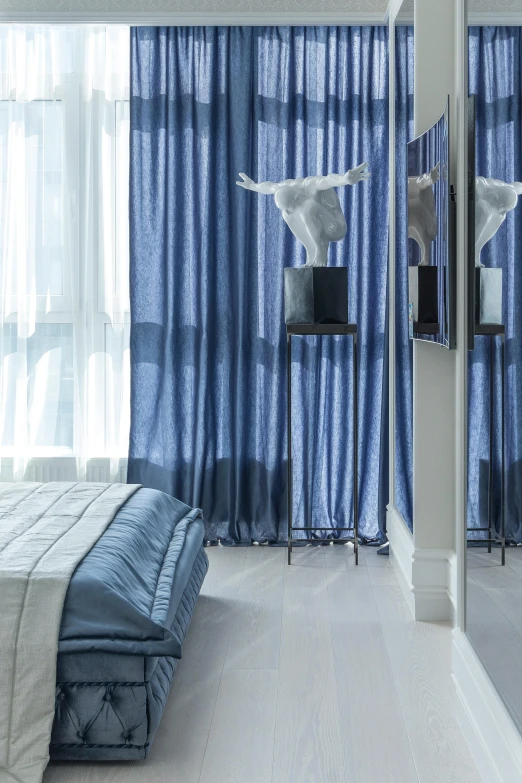 a bed room with a neatly made bed and blue curtains, an abstract sculpture, close up angle, luxury condo interior, anton fedeev, blue and silver