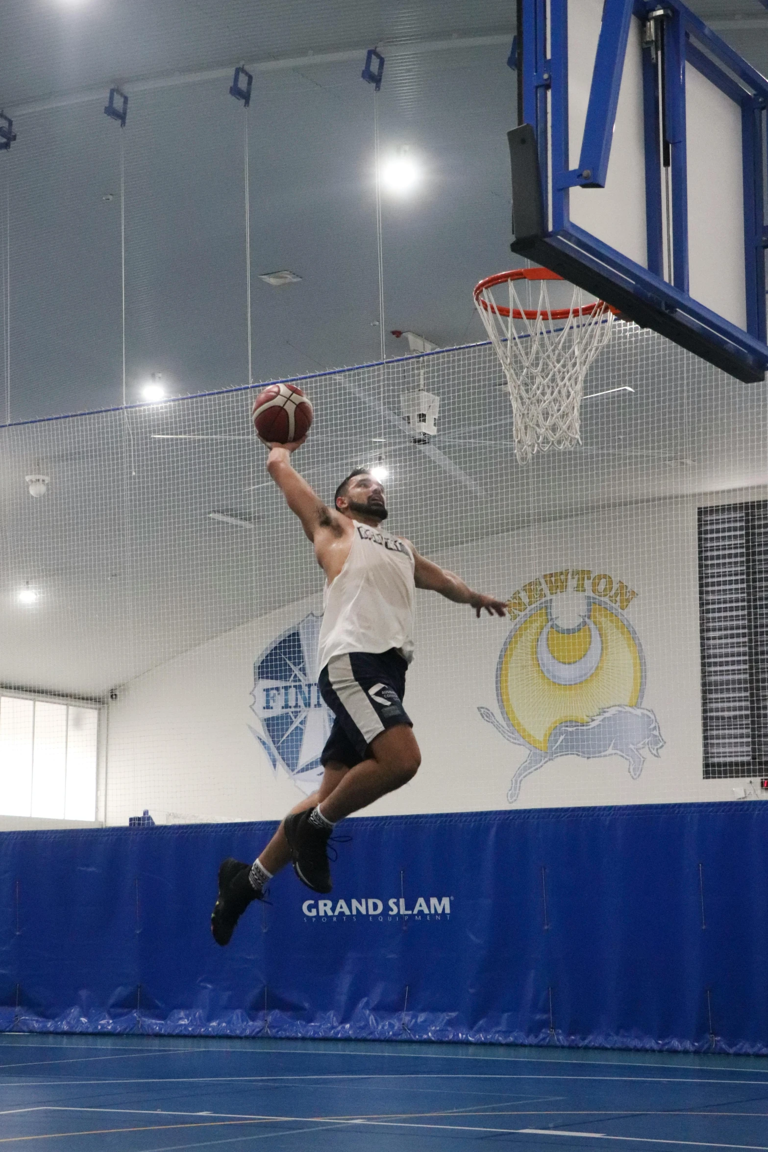 the man is playing basketball in the gym