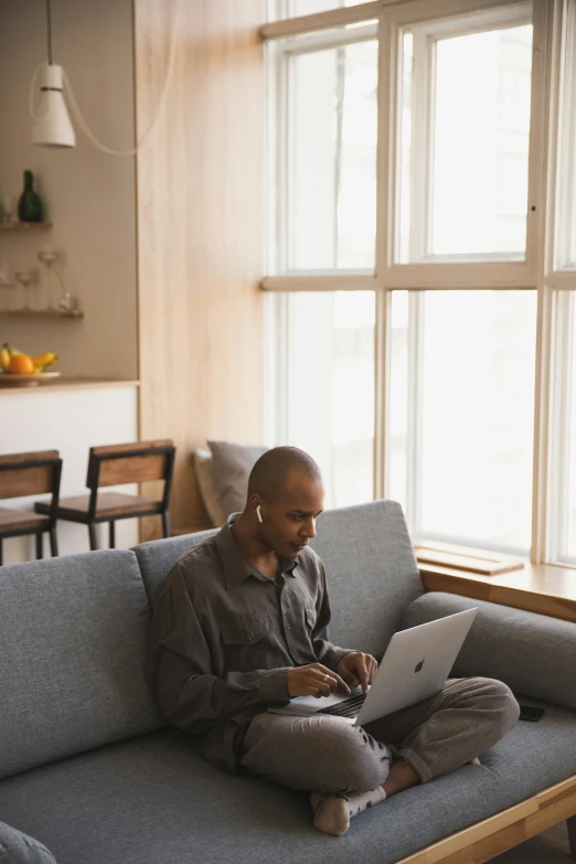 a man sitting on a couch using a laptop, pexels contest winner, renaissance, african american, official screenshot, big windows, connectivity