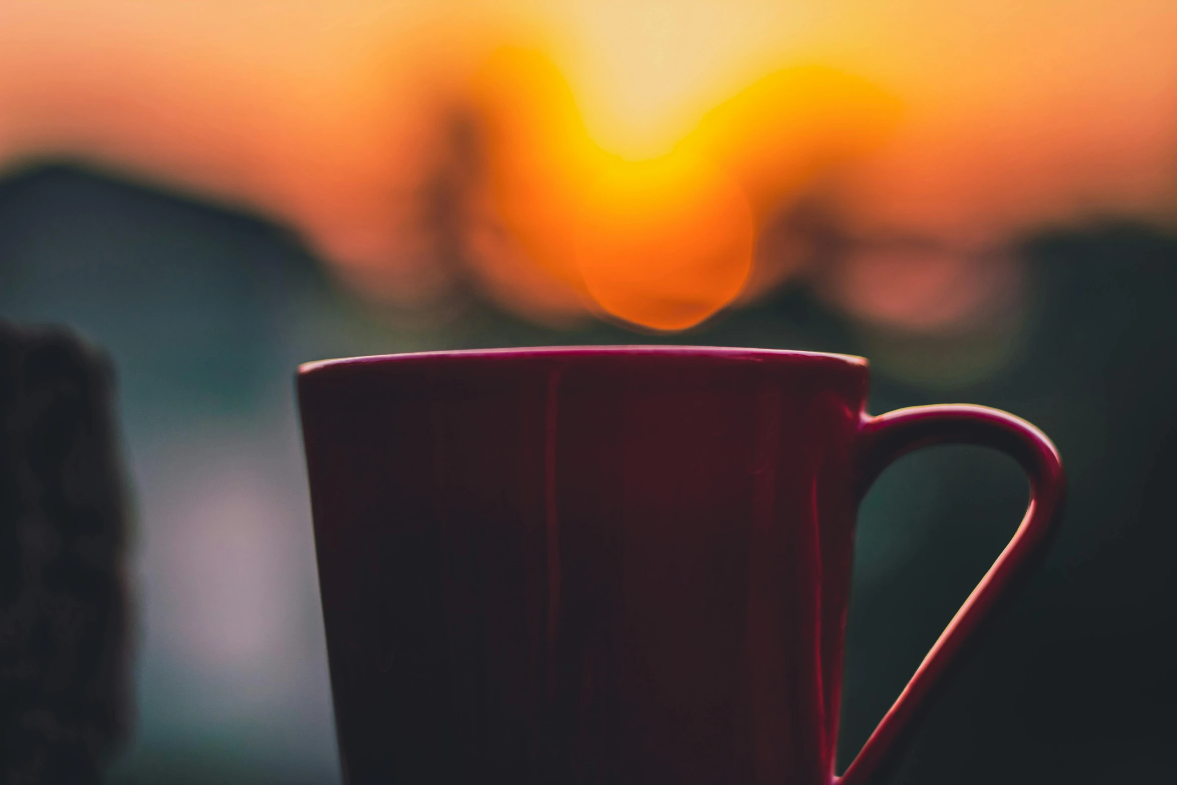 a red coffee cup sitting on top of a wooden table, pexels contest winner, romanticism, colorful sunset, sun down, looking off into the sunset, slice of life