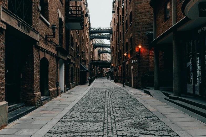 a cobblestone street with a bridge in the background, inspired by Thomas Struth, pexels contest winner, canary wharf, [[empty warehouse]] background, charli bowater, where a large