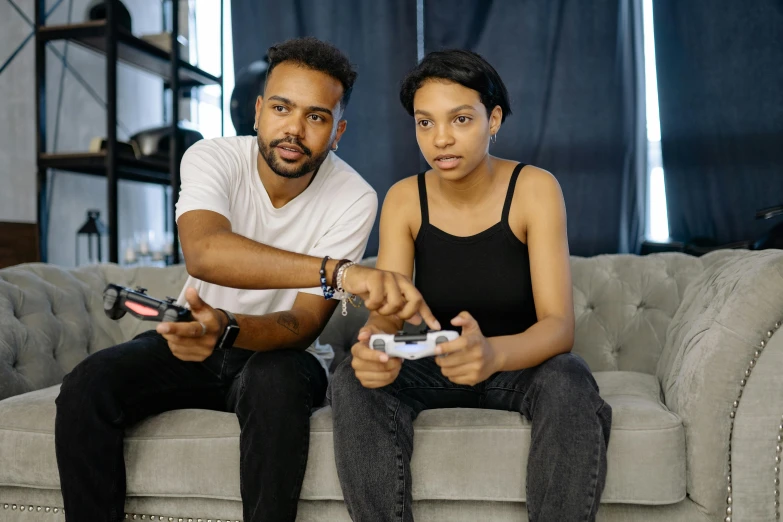 a man and a woman sitting on a couch playing a video game, pexels, ( ( dark skin ) ), instagram post, serious expression, 2020 video game screenshot