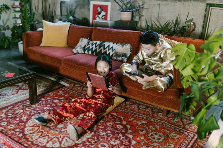 a woman sitting on a rug using a laptop computer