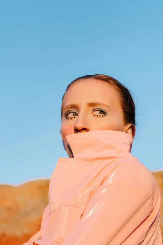 a woman in a pink jacket holding a tennis racquet, an album cover, by Julia Pishtar, sand dunes, big pink eyes, porcelain holly herndon statue, looking up at the camera
