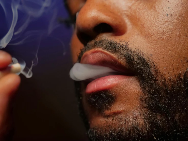a close up of a person smoking a cigarette, ray lewis, cannabis, beard stubble, photographed for reuters