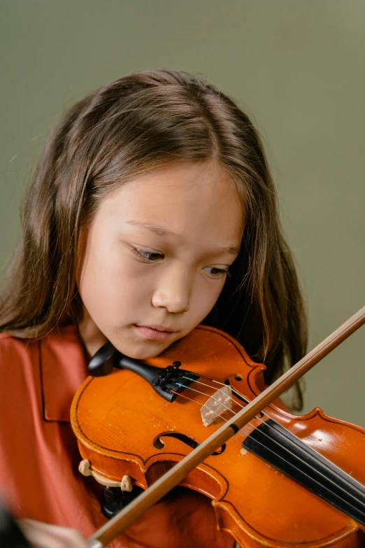 a little girl that is playing a violin, an album cover, pexels contest winner, danube school, looking serious, plain background, avatar image, profile pic