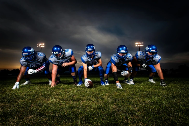 a group of football players standing on top of a field, a portrait, by Dan Luvisi, shutterstock, photorealism, dramatic white and blue lighting, high school, high quality product image”, dramatic lighting - n 9