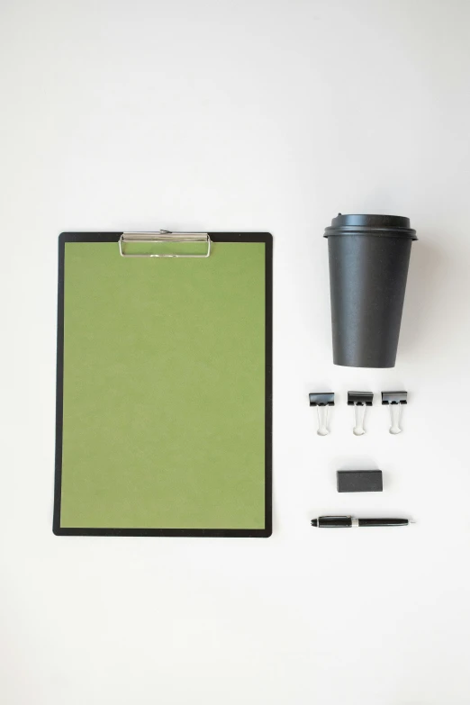 a clipboard sitting on top of a table next to a cup of coffee, minimalism, green and black color scheme, portrait n - 9, disassembled, no - text no - logo