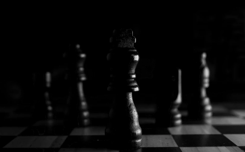 black and white chess pieces on a chess board, a black and white photo, by Adam Marczyński, pexels contest winner, digital art, black darkness, warfare, ( queen chess piece, shrouded in darkness