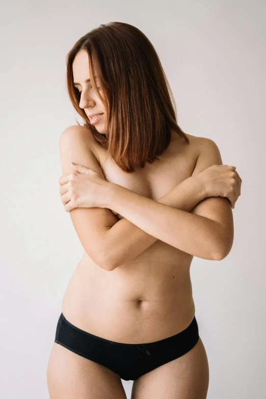 a woman in black underwear posing for a picture, an album cover, unsplash, with a white background, disrobed, maternal, bare midriff