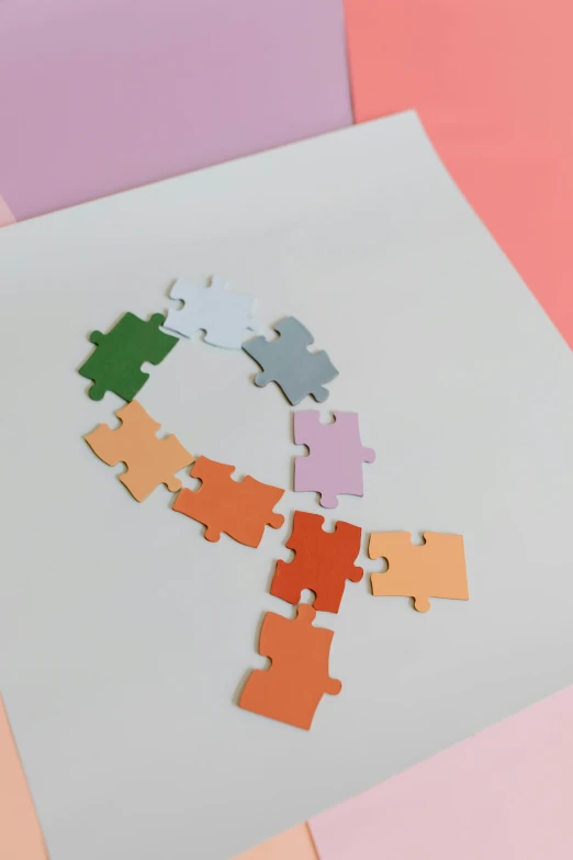 a piece of puzzle sitting on top of a piece of paper, inspired by Jean Arp, trending on pexels, letterism, pastel rainbow, pale orange colors, lesbians, building blocks