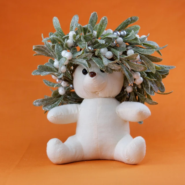 a white teddy bear with a wreath on its head, inspired by Leo Leuppi, trending on reddit, figuration libre, willow plant, white and orange, winter season, unique pot made for houseplants