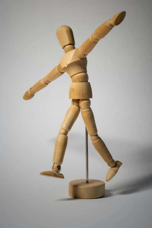 a wooden mannequin standing on a stand, by David Simpson, unsplash, kinetic art, playful pose, two arms and to legs, ilustration, low detail