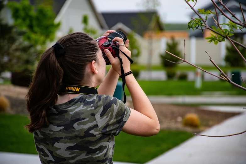 a woman taking a picture with a camera, a picture, by Sven Erixson, unsplash, sharp focus on houses, student, national geographic photo shoot, facing away from the camera