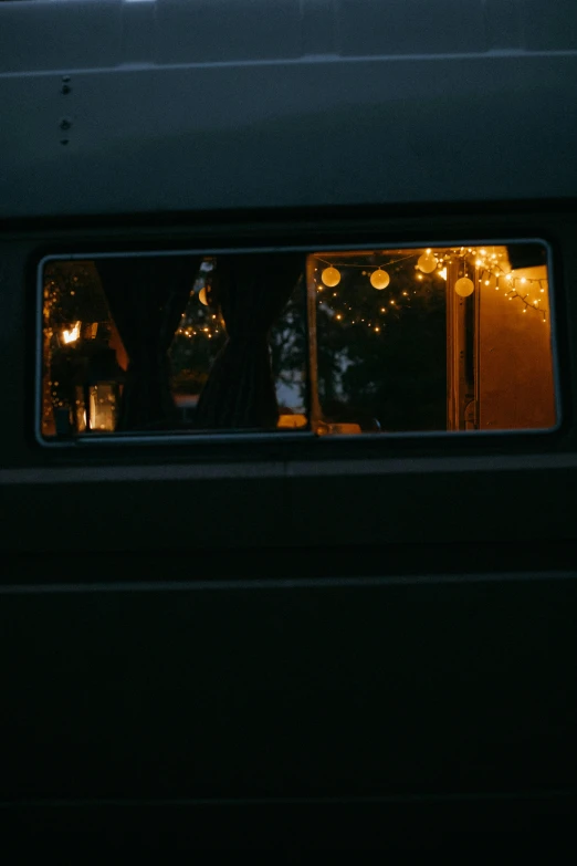 a train traveling down train tracks next to a forest, by Elsa Bleda, magical realism, 1 9 7 0 s car window closeup, christmas lights, next to an rv, 8k 50mm iso 10