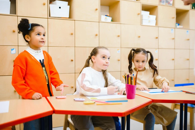 a group of children sitting at desks in a classroom, pexels contest winner, fan favorite, sitting at a table, ekaterina, professionally done