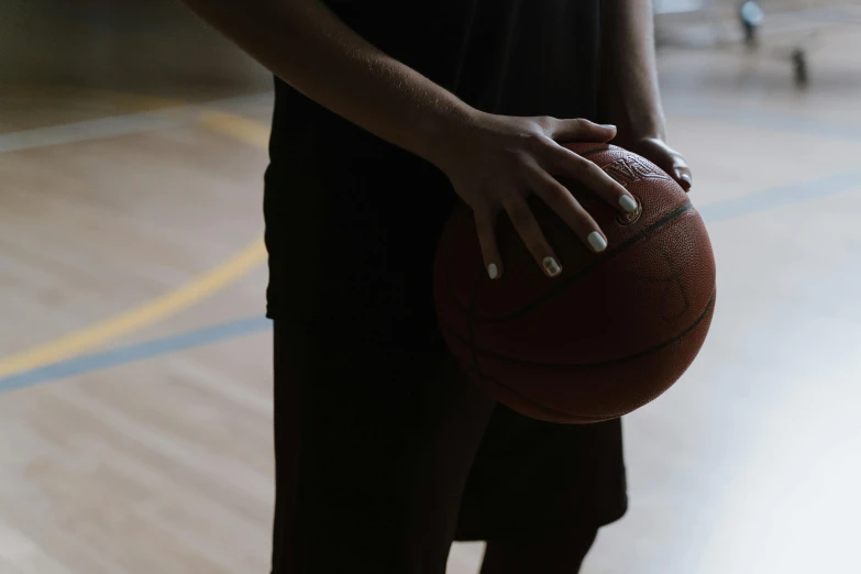 a close up of a person holding a basketball, basketball court, local gym, looking towards the camera, let's play