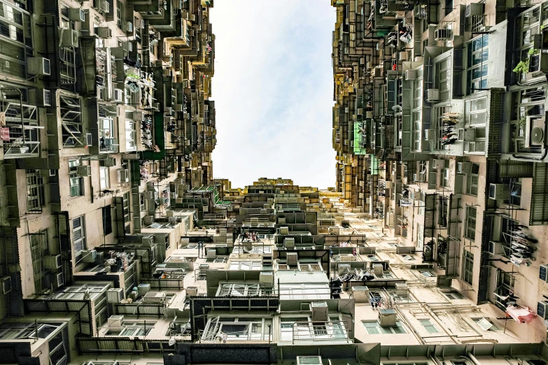 a very tall building with lots of windows, an album cover, inspired by Thomas Struth, unsplash contest winner, kowloon walled city style, stacked houses, snapchat photo, dezeen