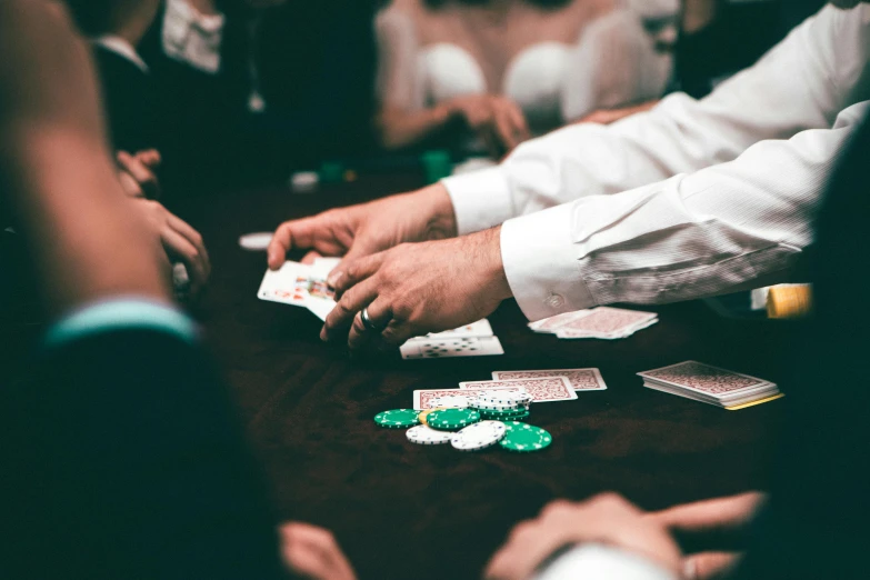 a group of people playing cards on a table, by Daniel Lieske, pexels contest winner, online casino logo, [ theatrical ]