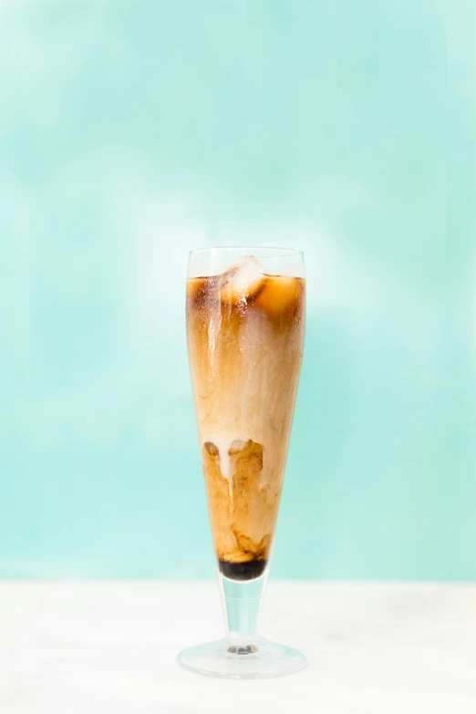 a glass of iced coffee sitting on top of a table, ice blue, tall shot, wide image, heavily upvoted