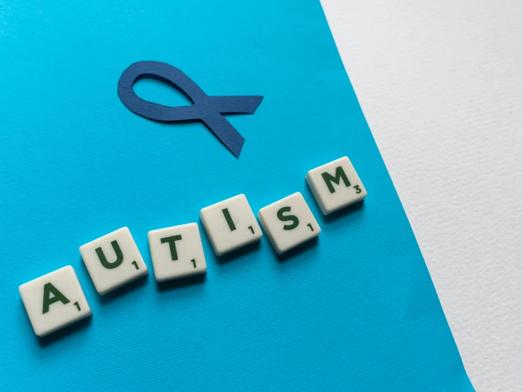 a blue ribbon with the word autism spelled on it, a jigsaw puzzle, trending on pexels, letterism, robots, children's, nft, aum