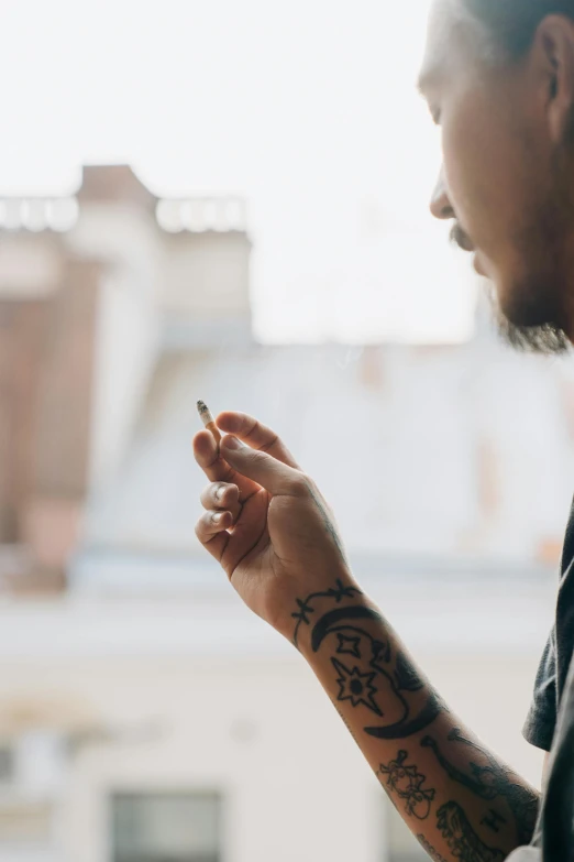 a man is looking at his cell phone, a tattoo, trending on pexels, visual art, praying with tobacco, pot leaf, light haze, looking off into the distance