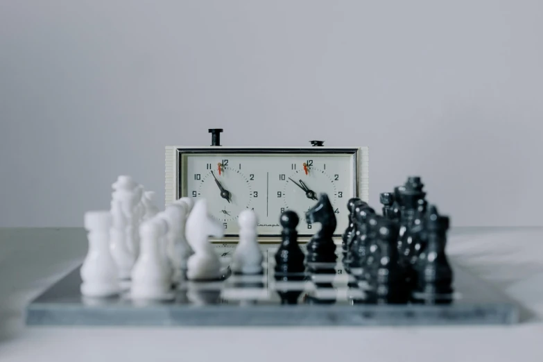 a clock sitting on top of a chess board, unsplash, hyperrealism, game and watch, on a white table, freeze time, close together