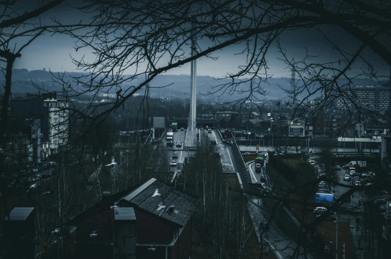 a view of a city from the top of a hill, by Sebastian Spreng, pexels contest winner, brutalism, extremely gloomy lighting, tall bridge with city on top, trees in the background, germany. wide shot