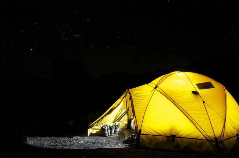a yellow tent is lit up in the dark, pexels contest winner, light and space, instagram post, mount, laser beam ; outdoor, brown
