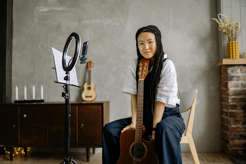 a woman sitting in a chair with a guitar, inspired by Song Xu, pexels contest winner, shin hanga, looking to camera, sitting in front of a microphone, oyasumi punpun, portrait of maci holloway