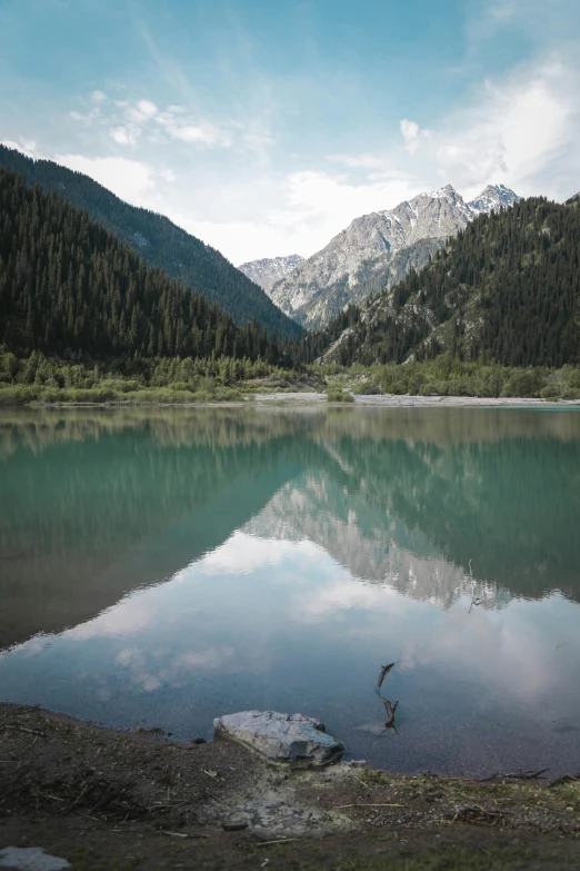 a body of water with mountains in the background, a picture, inspired by Konstantin Vasilyev, unsplash contest winner, hurufiyya, kazakh, glassy reflections, 2019 trending photo, evergreen valley