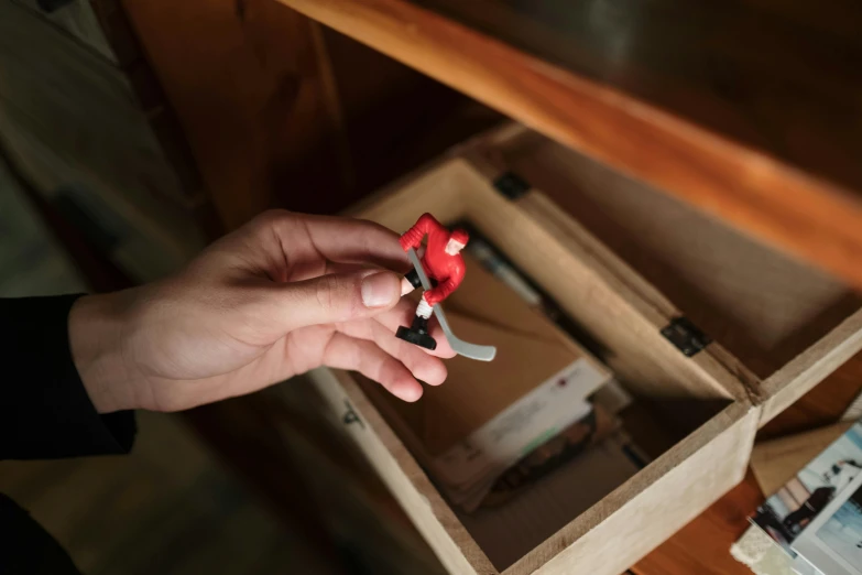 a person holding a pair of scissors in a drawer, a tilt shift photo, happening, the red ninja, mini model, full shot photograph, angled