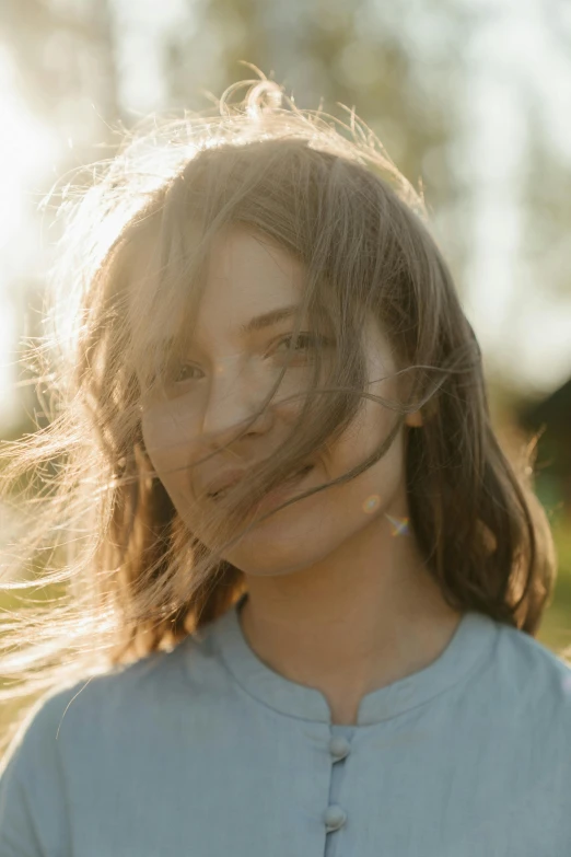 a girl with her hair blowing in the wind, a picture, by Attila Meszlenyi, trending on unsplash, medium format. soft light, portrait of normal teenage girl, friendly face, light brown neat hair