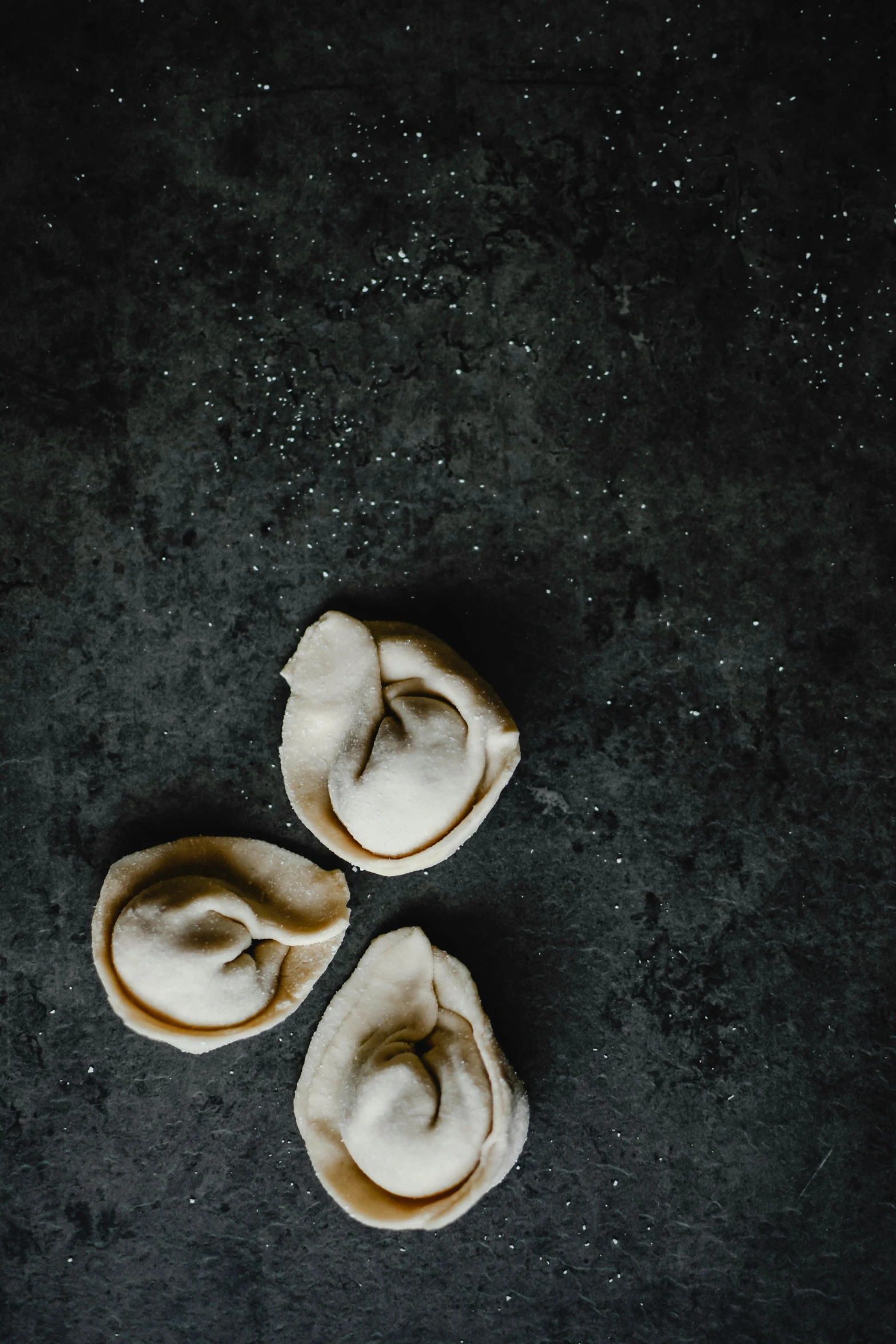 three dumplings sitting on top of a black surface, a picture, trending on unsplash, process art, turban, thumbnail, background image, 7