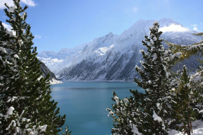 a large body of water surrounded by snow covered trees, by Muggur, pexels contest winner, hurufiyya, lakeside mountains, avatar image, 2000s photo, fan favorite