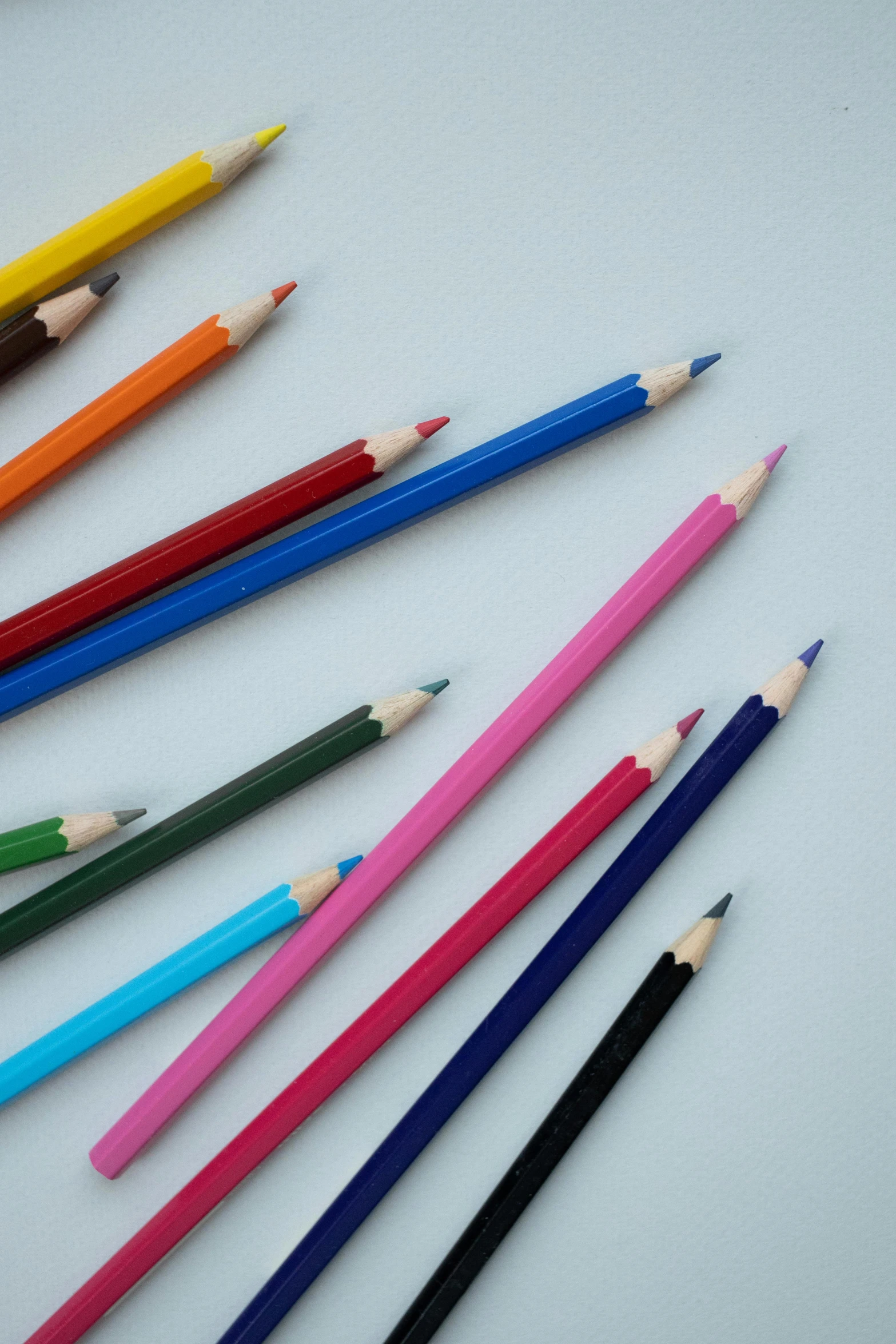 a group of colored pencils sitting next to each other, cobalt blue and pyrrol red, multi - coloured, up close image, on a gray background