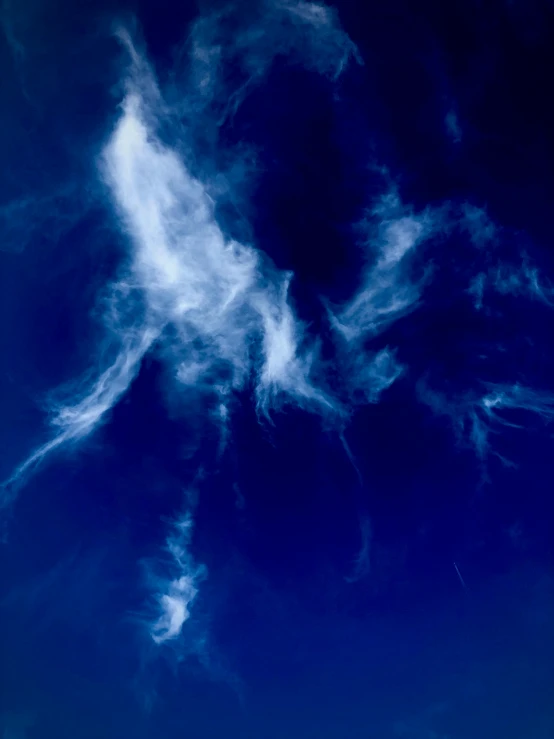 a large jetliner flying through a blue sky, inspired by Lucio Fontana, unsplash, lyrical abstraction, white thick smoke, ignant, cyanotype, clouds of vivid horse-hair wigs