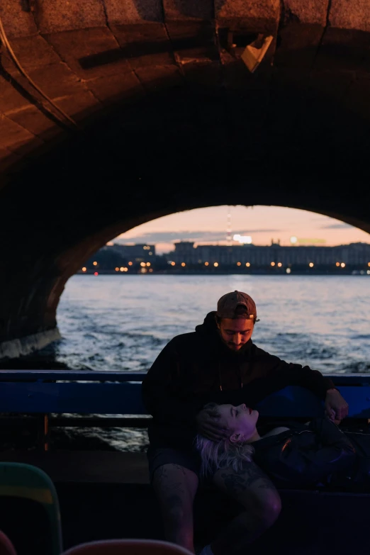 a man sitting on a boat in the water, inside the tunnel, at dusk, in moscow centre, sleepy feeling