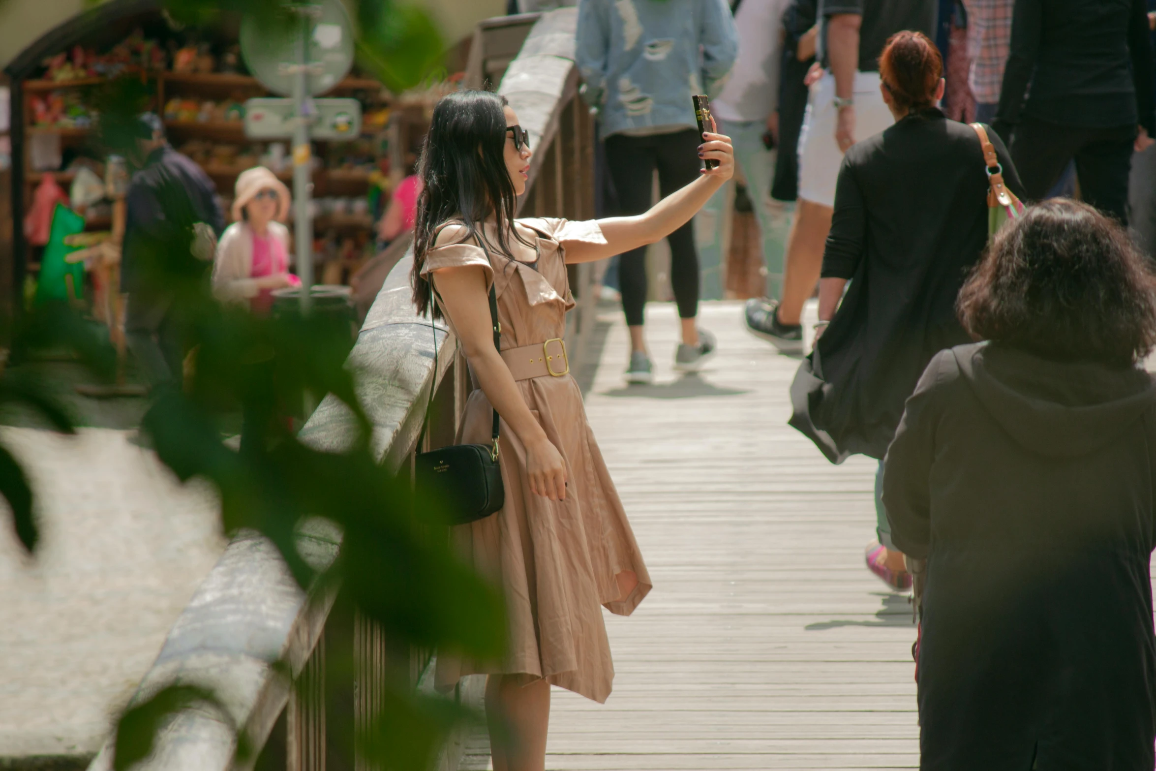 a woman taking a picture of herself on a bridge, trending on pexels, realism, gemma chan, people walking around, cardboard, wearing a dress