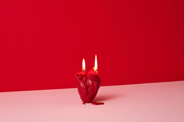 a couple of red candles sitting on top of a table, inspired by Marina Abramović, magic heart, medium-shot, melted, 20k