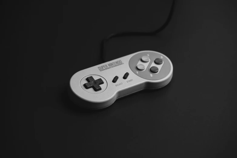 a close up of a game controller on a table, a black and white photo, by Jan Kupecký, computer art, super nintendo, miniature product photo, white and grey, on a gray background