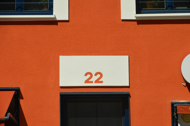 a close up of a building with a number on it, inspired by Bauhaus, pexels contest winner, postminimalism, orange, # 2 2 3 3 e 6, private academy entrance, -n 2